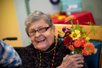 A woman smiling and holding some flowers